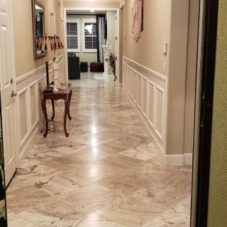 A well-lit hallway with marble flooring and classic decor.