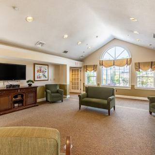 A spacious living room with comfortable seating and a large window.