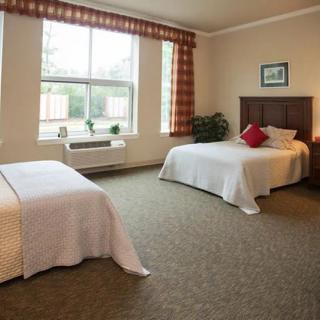 A cozy bedroom with twin beds and a large window.