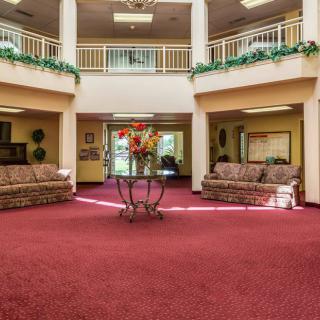 A spacious lobby with red carpet, featuring sofas and decorative elements.