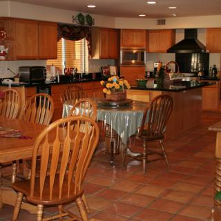 A spacious kitchen and dining area with wooden furniture and modern appliances.