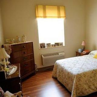 Cozy bedroom interior with wooden furniture and soft lighting.