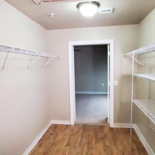 A spacious walk-in closet with shelving and hanging space.