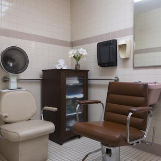 A well-equipped salon space featuring a styling chair and essential amenities.