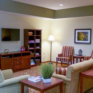 A cozy living room with comfortable seating, a television, and a well-stocked bookshelf.