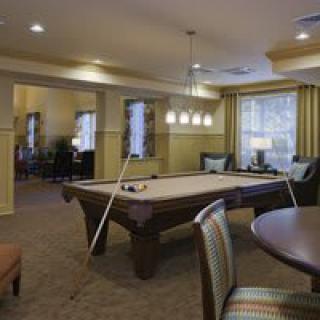 A cozy game room featuring a billiards table and comfortable seating.