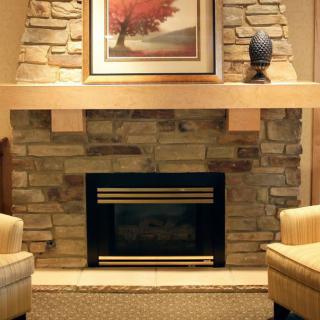 A cozy living room with a stone fireplace and comfortable armchairs.