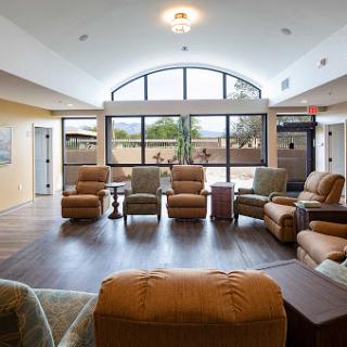 A spacious and sunlit lounge area featuring comfortable recliners, designed for relaxation.