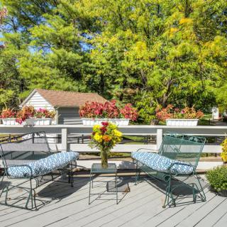 A serene outdoor patio with comfortable seating and vibrant floral arrangements.
