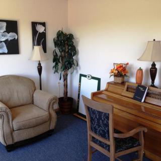 A cozy living room corner with a chair, desk, and decorative elements.