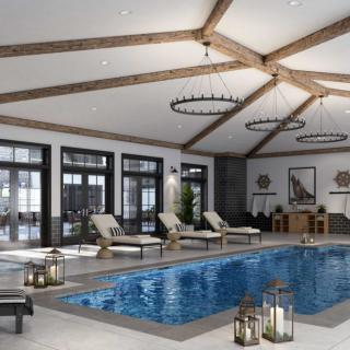 A luxurious indoor pool area with lounge chairs and elegant lighting.