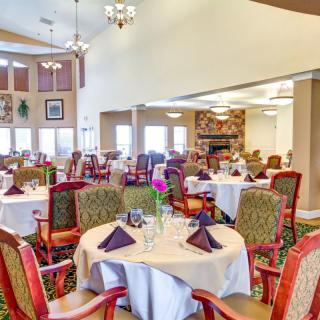 A brightly lit dining area with elegantly set tables and comfortable seating.