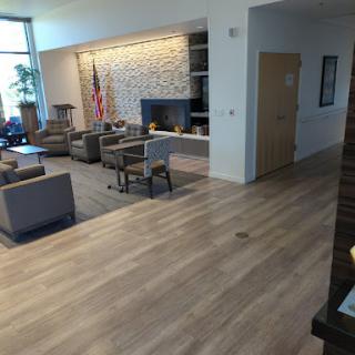 A modern waiting area with comfortable seating and a wooden floor.