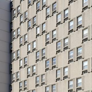 A repetitive pattern of windows on an urban apartment building facade.
