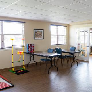 A recreational room with tables, chairs, and games.