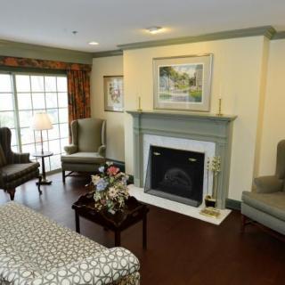 A cozy living room with a fireplace, sofa, and armchairs.