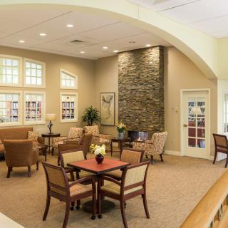 A cozy and elegantly decorated living room with comfortable seating, tables, and a stone accent wall.