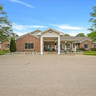 A welcoming entrance to a modern residential building with well-maintained landscaping.