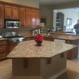 A kitchen featuring a granite island and wood cabinets.