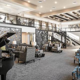 A spacious and elegant lounge area featuring a grand piano, modern furniture, and a stylish staircase.