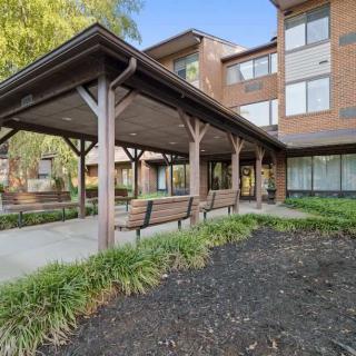 A view of a residential building with a covered walkway and benches.