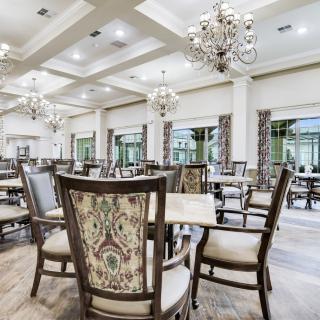 An elegantly designed dining room featuring luxurious chandeliers and patterned chairs.