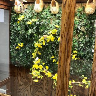 A serene indoor space featuring vibrant yellow flowers and decorative wooden elements.