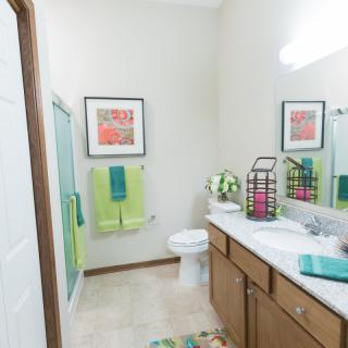 A well-decorated bathroom with bright green accents and modern fixtures.