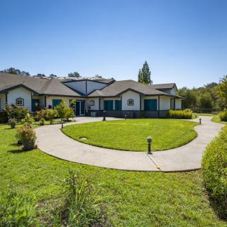 A spacious residential home with a well-maintained lawn and circular driveway.