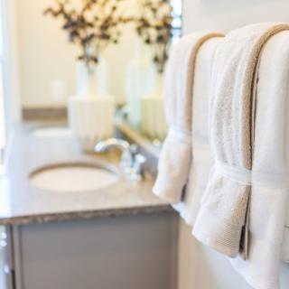 A neatly arranged bathroom with white towels and decorative elements.