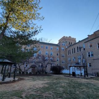 A residential area featuring a playground surrounded by apartment buildings and trees.