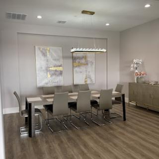 A modern meeting room featuring a stylish dining table, sleek chairs, and contemporary artwork on the walls.
