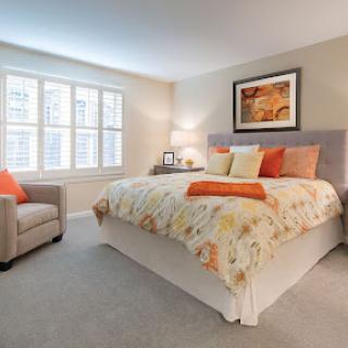A beautifully designed cozy bedroom featuring a floral patterned bedspread and soft lighting, perfect for relaxation.