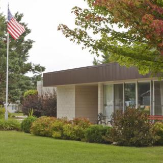 A suburban house with an American flag and well-maintained landscaping.