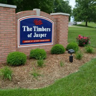 Entrance sign for 'The Timbers of Jasper' surrounded by well-maintained landscaping.