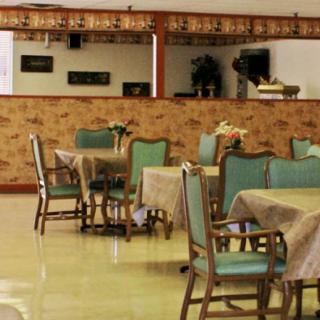 An empty restaurant dining area with neatly arranged tables and chairs.