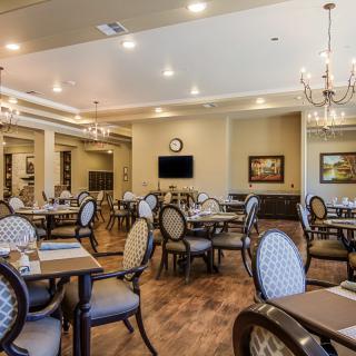 An elegant dining room with chandeliers and neatly arranged tables and chairs.