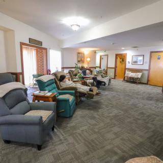 A cozy living room with comfortable seating and carpet flooring.