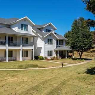A suburban residential building with a well-maintained lawn and trees.