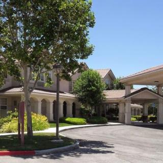 A view of a residential building with a landscaped entrance and driveway.