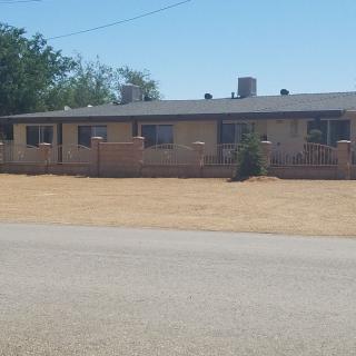 A single-story brick house with a dry yard in a suburban area.