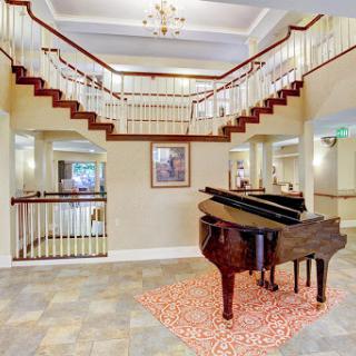 An elegant lobby featuring a grand piano and a stylish staircase.