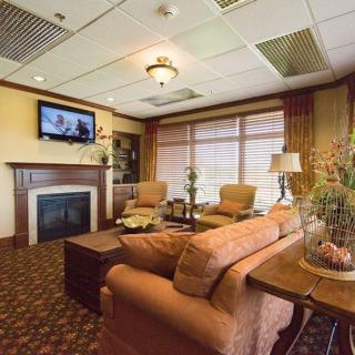 A cozy living room featuring comfortable seating, a fireplace, and a television.