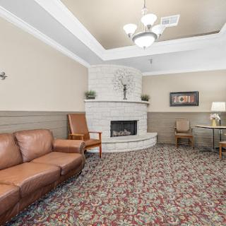 A cozy living room featuring a leather sofa and a decorative fireplace, perfect for relaxation and gatherings.
