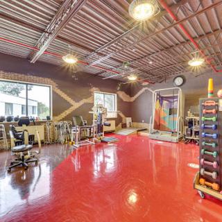 A spacious and vibrant gym area equipped for various fitness activities.
