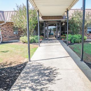 A welcoming entrance path leading to a building, framed by well-maintained landscaping.