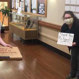 Healthcare workers expressing gratitude with a thank you sign, showcasing community support.