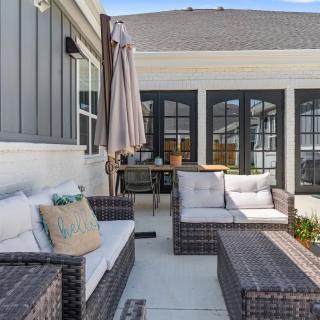 A cozy patio with wicker furniture and cushions, featuring a modern outdoor design.