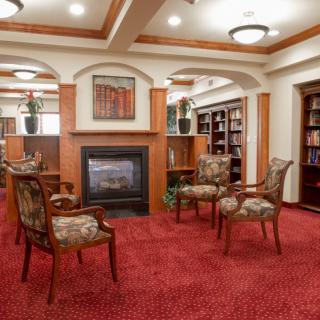 A cozy reading area with a fireplace and bookshelves.