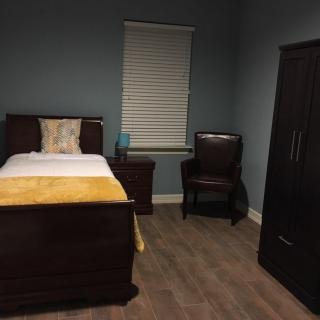 A cozy bedroom with a single bed, wardrobe, and nightstand.